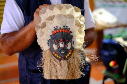 Juan Carlos shows an indigenous mask using the Pirarucú fish scales as adornment